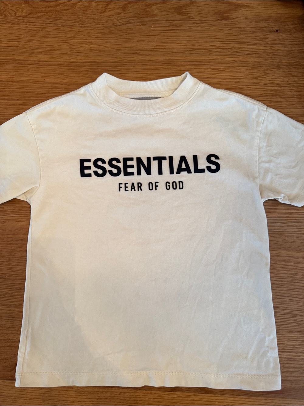 Fear of God ESSENTIALS Kids T - Black Logo front & plastic badge on back